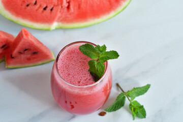 Fresh watermelon juice with mint and ice in the glass on white table.Sweet summer dessert, smoothie,cocktail healthy food concept, close up.Summertime. Copy spase. Selective focus