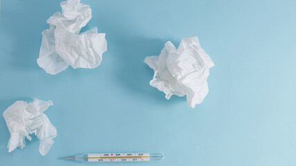 used paper handkerchief thermometer, on a blue background. Virus concept