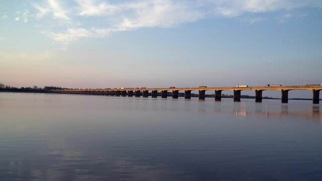 Beautiful view of bridge over the Uruguay River on the border of Uruguaiana city, Brazil and Paso de los Libres, Argentina on sunny summer day. Trucks driving on dusk.  Concept of travel, transport.