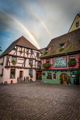 podwójna tęcza nad kolorowymi domkami w średniowiecznej wiosce Riquewihr, Alzacja, Francja - obrazy, fototapety, plakaty