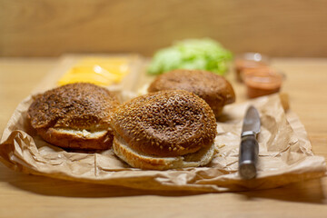 Burger bread, lettuce and cheese on the table. Process of cooking self made burgers at home