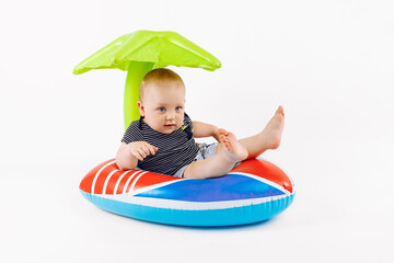 Little happy child on an inflatable swimming ring, on an white background