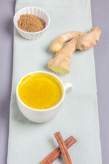 Moon milk for better sleep. Turmeric Golden Milk with Cinnamon. Ayurvedic drink. Popular drink. Golden latte on a light background. Indian drink turmeric golden milk in a cup