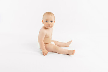 Happy baby in diaper sitting on isolated white background