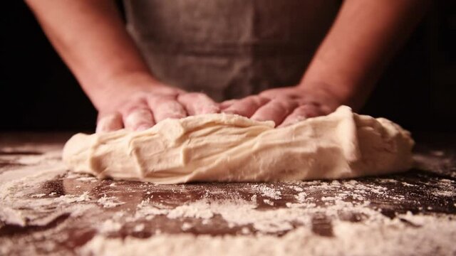 Rolling out dough on a wooden board in kitchen. Process of making pastry