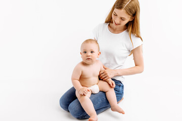 mother holds her little son in her arms and looks at him, on a white background