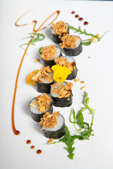 Shrimp sushi roll with fried onion on top. Vertical image