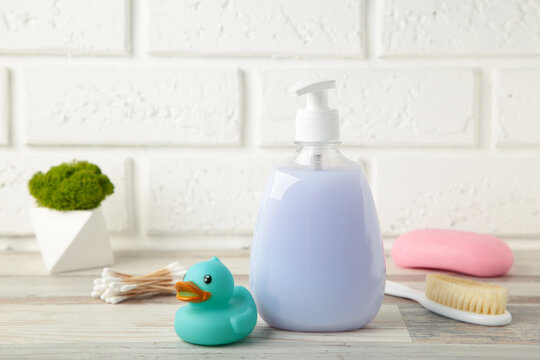 Baby shower gel, soap, rubber duck, comb on table.