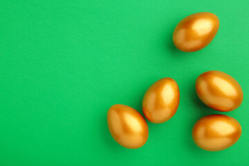 Gold eggs on green background. Easter concept.