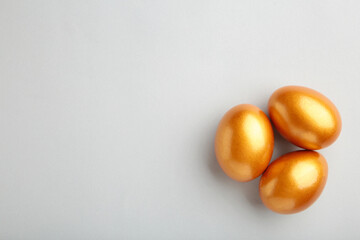 Gold Easter eggs on grey background. Spring concept.