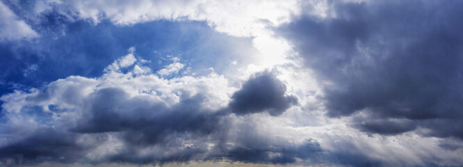 Obraz premium Cloudy sky in sunny weather with glowing rays through the clouds.