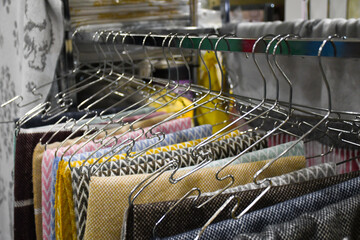 Fabric of different colors and textures hangs on a hanger.
Mix of pastel colors and textiles. Textile fabric