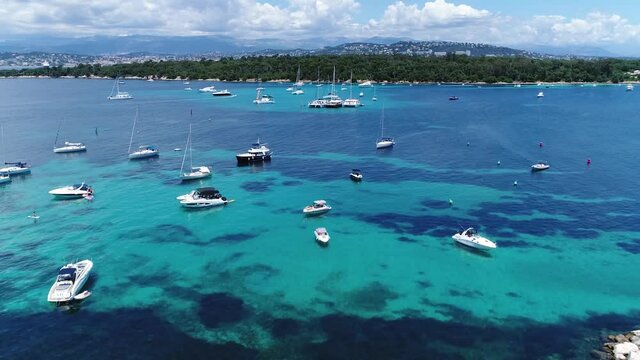 Aerial bird view of Lerins Islands about half mile off shore from the French Riviera town of Cannes showing large number of boats moor in shallow and protected Plateau du Milieu between the islands 4k