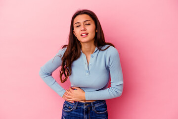 Young Indian woman isolated on pink background having a liver pain, stomach ache.