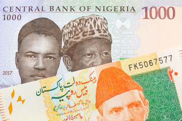 A macro image of a blue, purple and green one thousand  naira note from Nigeria paired up with a orange and green 20 rupee note from Pakistan.  Shot close up in macro.