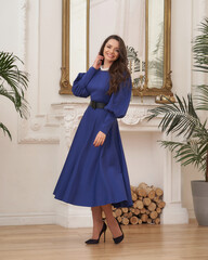 Beautiful caucasian woman wearing blue sundress dress. Elegant female model with make-up and wavy...