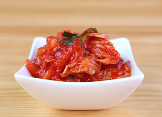 Closeup of Kimchi, an Iconic Korean Dish in White Bowl on Wooden Background