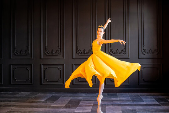 Fototapeta elegant ballerina in pointe shoes dances in long yellow skirt