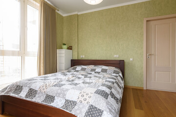 The interior of the bedroom with a large double bed, next to the interior door