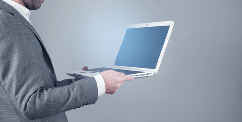 Businessman using laptop computer in office.