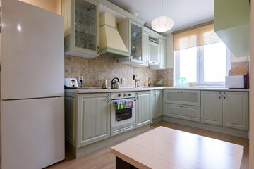 Interior of a modern classic kitchen with a corner kitchen set by the window