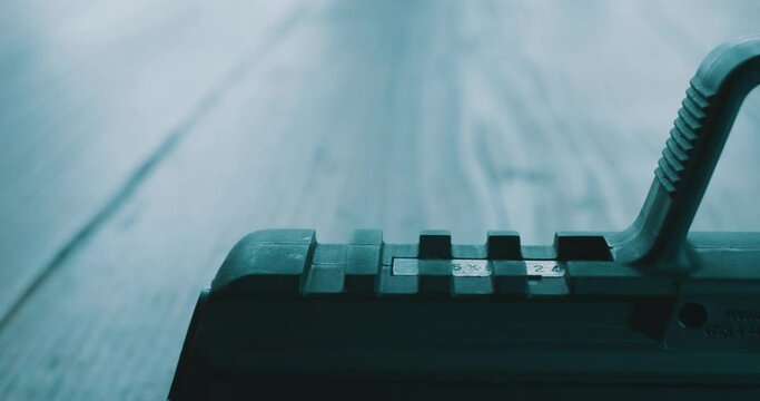 Black hand gun pistol on table - close up macro slider shot 