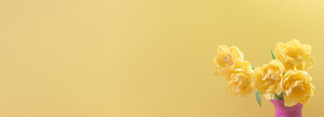 Naklejka premium Bouquet of tulips on a yellow background. Banner