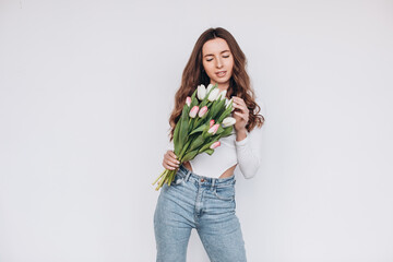 Image of screaming excited beautiful young woman standing isolated holding tulips flowers. 