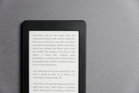 Closeup image of an electronic reader with text on the screen on a grey surface