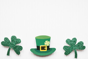St Patricks Day shamrocks and green hat on white background with copy space
