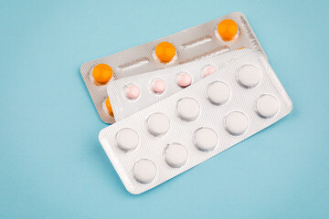 View of tablets in a blister, on a blue background.