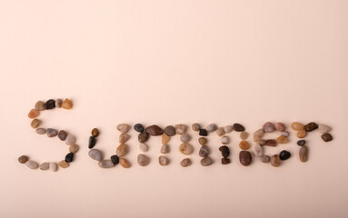 summer written with beach stones