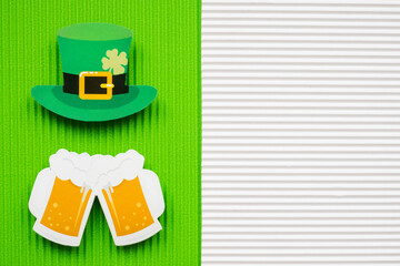 St Patricks Day hat and beer on green and orange background with copy space