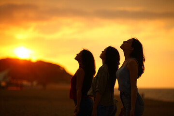 Three friends breathing fresh air at sunset