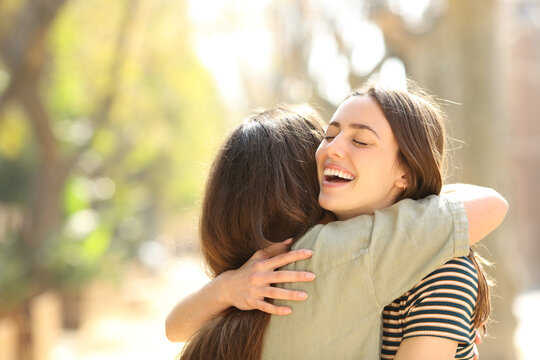Two happy women embracing meeting in the street