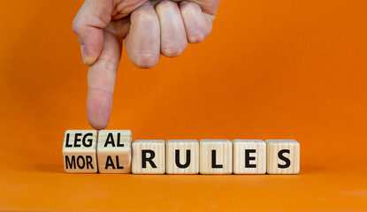 Legal or moral rules symbol. Businessman turns wooden cubes and changes words 'legal rules' to...