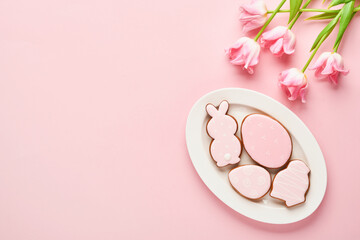 Easter table setting with floral decor and plate with easter gingerbread on pink table. Elegance dinner. Mock up. Top view.