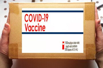 medical worker holding a box containing doses of covid-19 vaccines