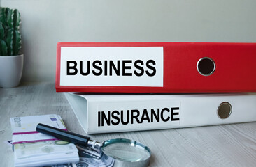 Red and white folders with documents lying on the desktop next to a calculator and a pen. The lettering on the folder has financial or marketing significance. Business concept.