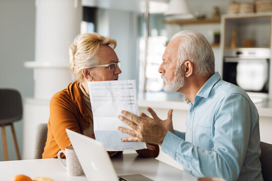 Frustrated senior couple arguing about their home finances at home - Powered by Adobe