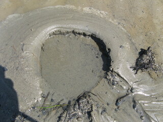 a sink hole with quicksand at a tidal beach at the coast along the sea