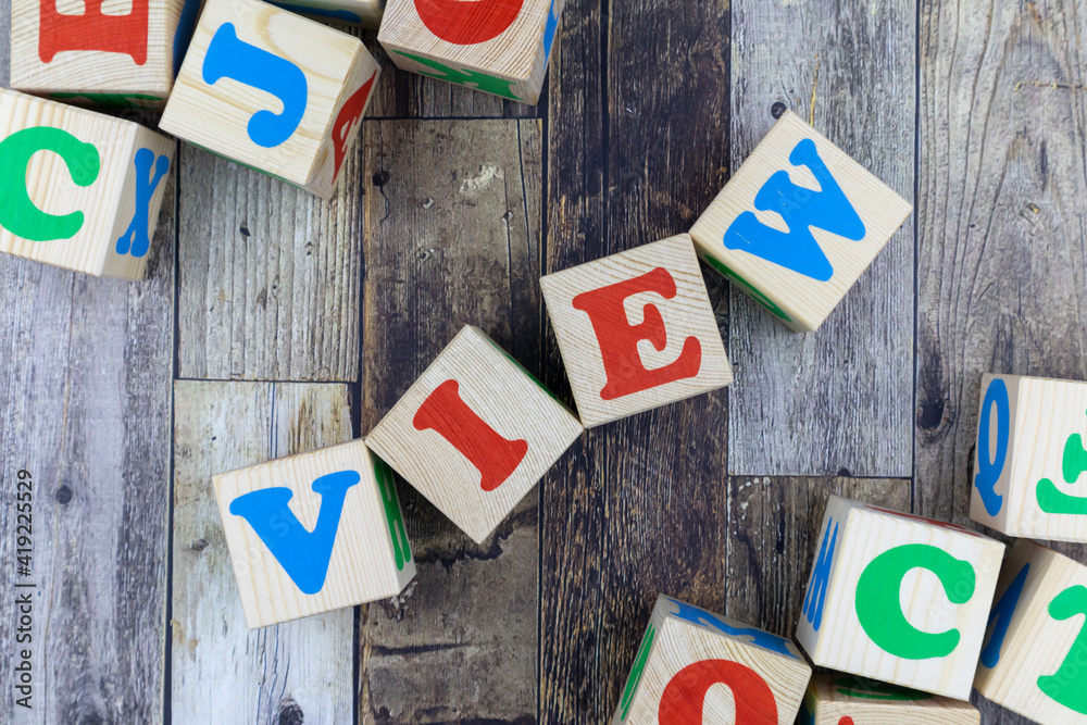 Fototapete colourful alphabet letters on wooden cubes with word - view - in a diagonal line with additional blo