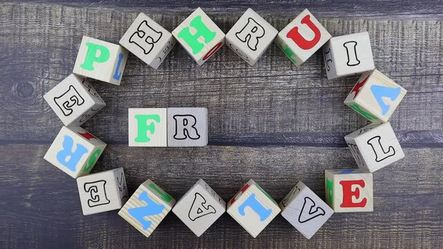 Word - Fresh - in colorful alphabet letters on wooden cubes surrounded by a frame of additional random blocks over a textured textile background. Stop motion, top view
