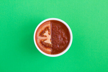 Top view of homemade tomato ketchup and tomato on the green background.  Close-up. Copy space.