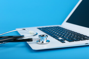 stethoscope on a laptop on a blue background. online medicine concept. computer repair concept.