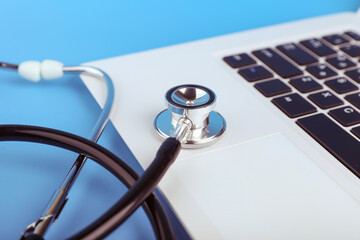 stethoscope on a laptop on a blue background. online medicine concept. computer repair concept. 