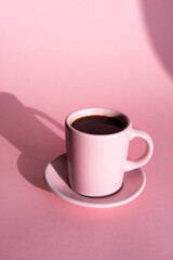 Obraz na płótnie Canvas Pink cup of coffee with pink background and coffee beans