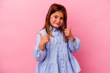 Little caucasian girl isolated on pink background  raising both thumbs up, smiling and confident.