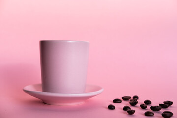 Pink cup of coffee with pink background and coffee beans