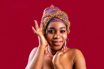 glamour dark skin woman wrapped on turban in studio in red background